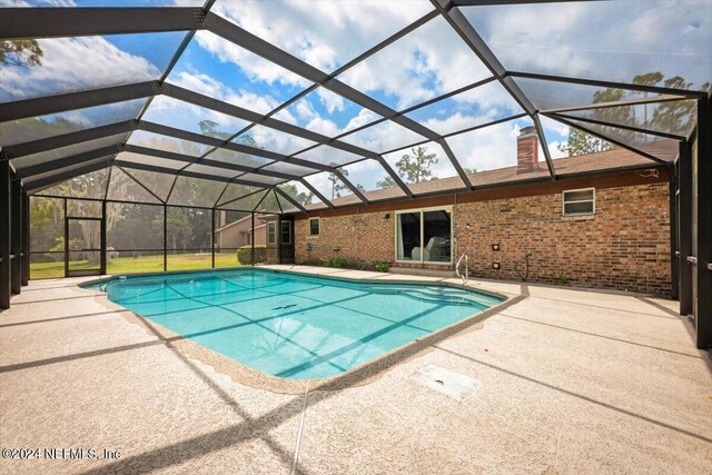 view of pool with a patio and a lanai