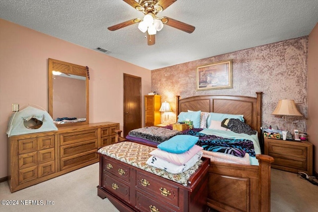 carpeted bedroom featuring ceiling fan and a textured ceiling