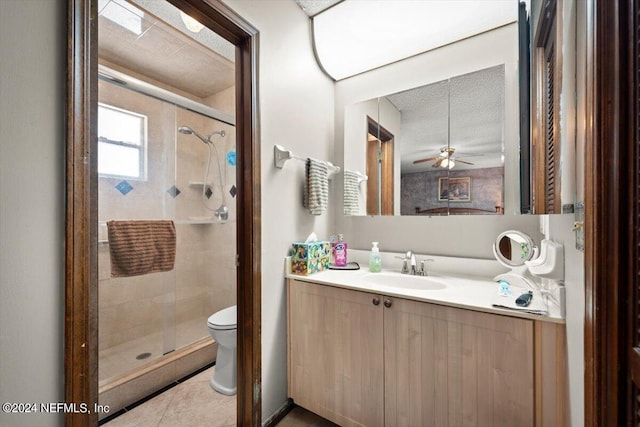 bathroom featuring ceiling fan, a shower with door, a textured ceiling, toilet, and vanity