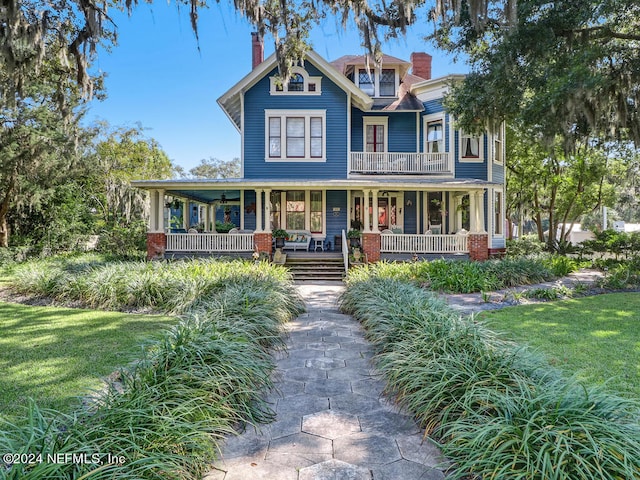 view of front of house with covered porch and a front lawn