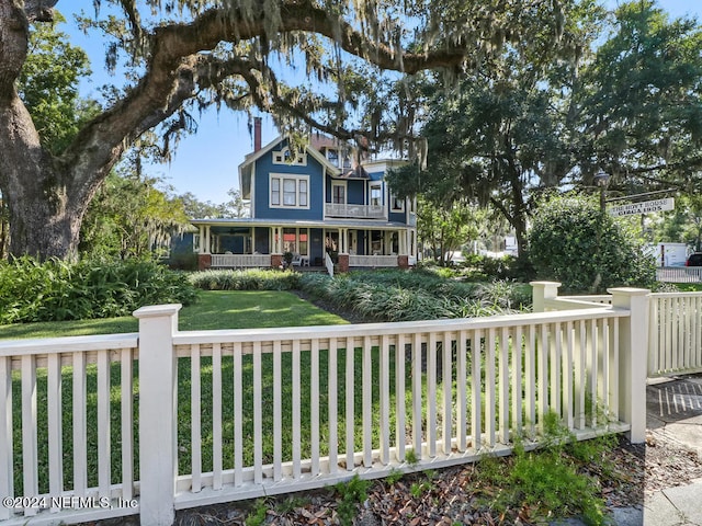 victorian house featuring covered porch and a front yard