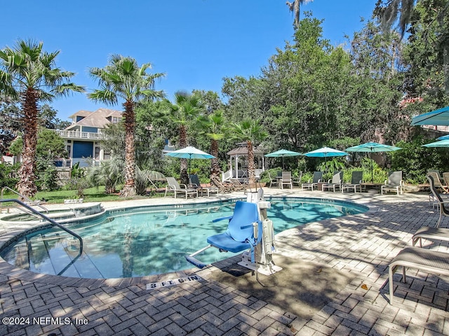 view of pool with a patio and a hot tub