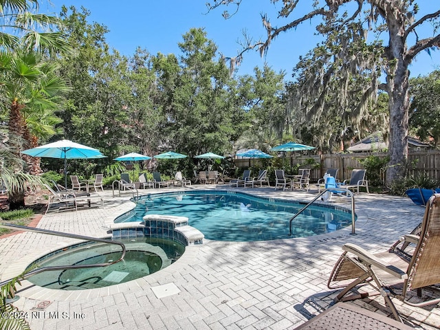 view of swimming pool featuring an in ground hot tub and a patio