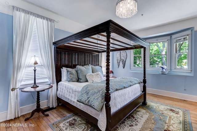 bedroom with a chandelier and hardwood / wood-style floors