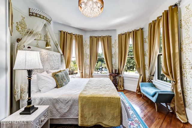 bedroom with hardwood / wood-style floors and a notable chandelier