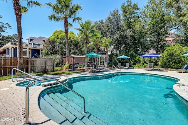 view of pool with a patio area and a hot tub