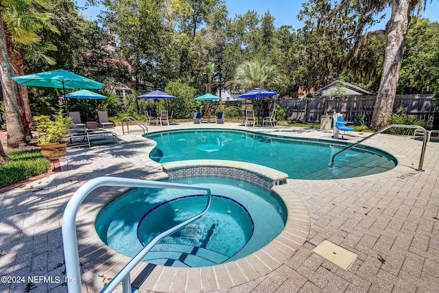 view of pool with an in ground hot tub and a patio