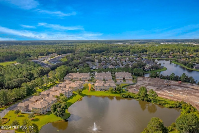 drone / aerial view featuring a water view, a residential view, and a view of trees