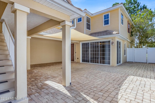 rear view of house with a patio area, a gate, and fence