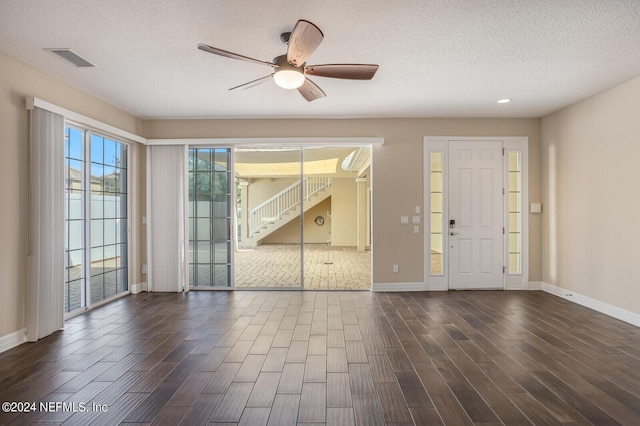 entryway featuring a textured ceiling, wood finished floors, a ceiling fan, visible vents, and baseboards