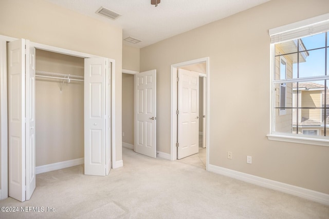 unfurnished bedroom featuring carpet floors, a closet, visible vents, and baseboards