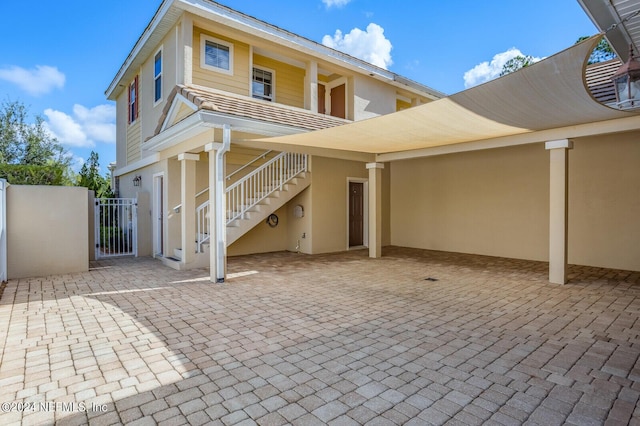 back of house featuring stairs, a patio, fence, and a gate