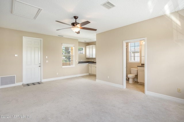 unfurnished living room featuring visible vents, light carpet, and baseboards