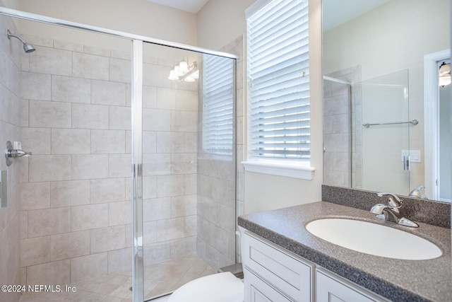 bathroom with toilet, a stall shower, and vanity