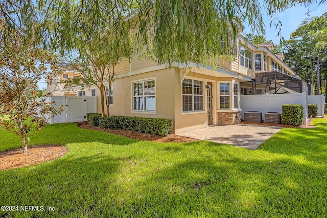 back of house with a patio area, fence, a lawn, and stucco siding