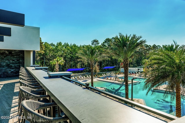 view of swimming pool with exterior bar