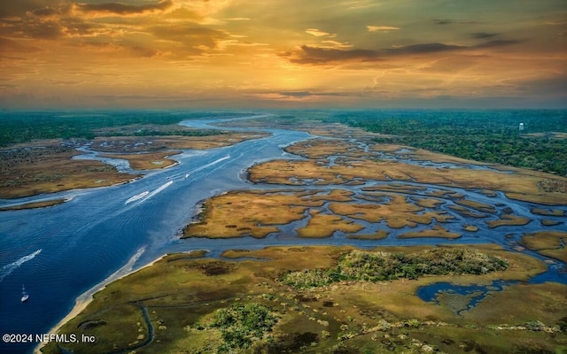 aerial view at dusk featuring a water view