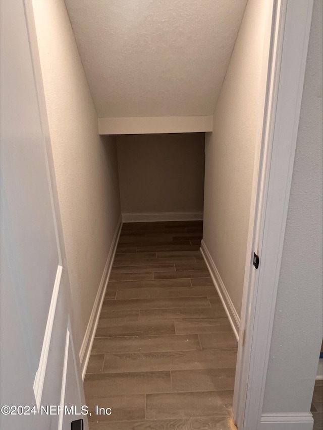 corridor featuring dark hardwood / wood-style flooring and a textured ceiling