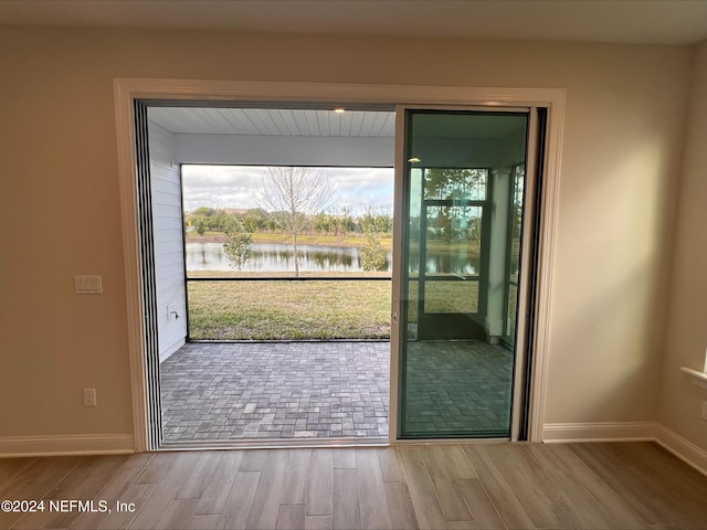 doorway to outside featuring a water view and wood-type flooring