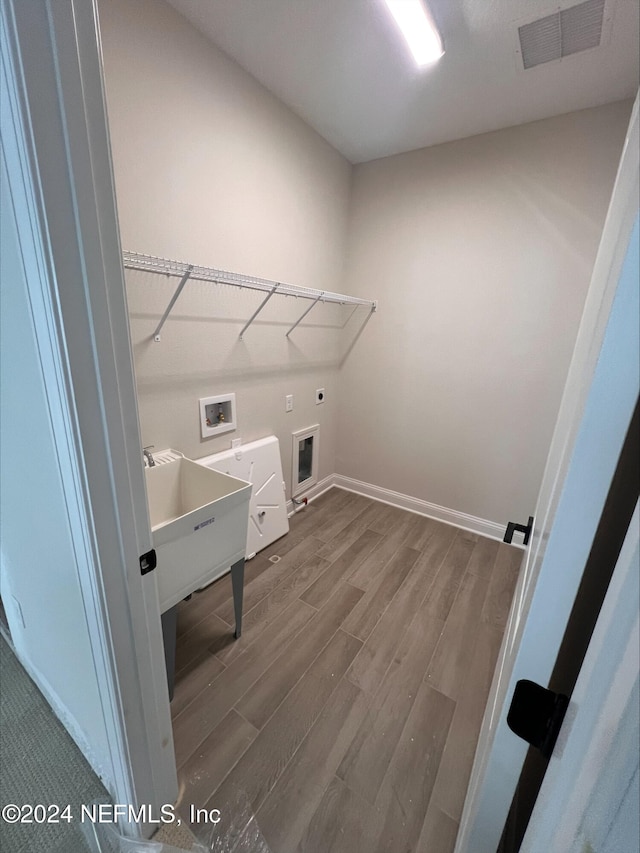 washroom with washer hookup, hardwood / wood-style flooring, electric dryer hookup, and sink