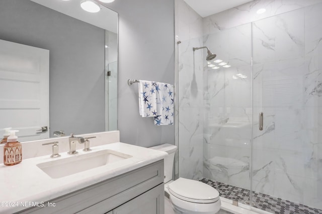 full bath featuring toilet, vanity, and a marble finish shower