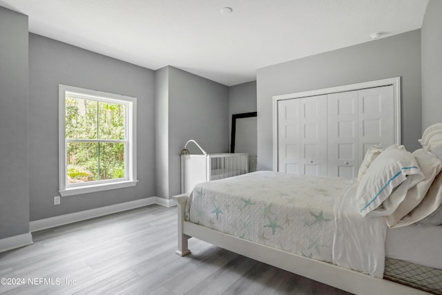 bedroom with a closet, baseboards, and wood finished floors