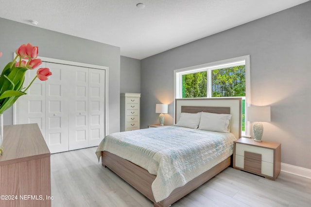 bedroom with light wood-type flooring and a closet