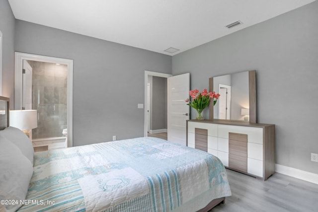 bedroom with light hardwood / wood-style flooring and ensuite bath