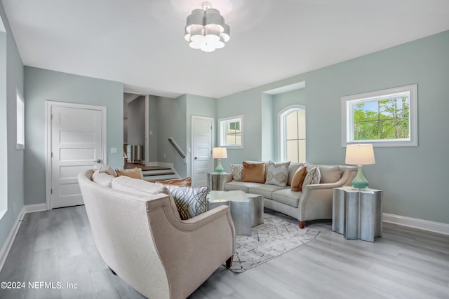 living room with light hardwood / wood-style floors and a notable chandelier