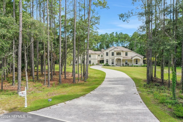 view of front of house featuring decorative driveway and a front lawn