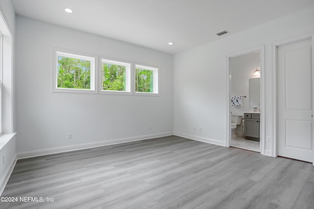 unfurnished bedroom with recessed lighting, light wood-style flooring, and baseboards