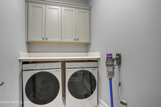 laundry room featuring washing machine and clothes dryer and cabinet space