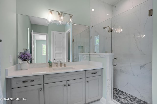 bathroom with vanity and a marble finish shower