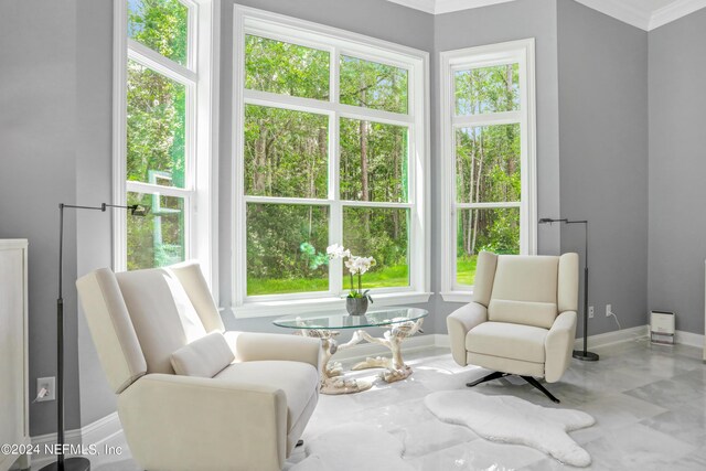 sitting room featuring a wealth of natural light and crown molding