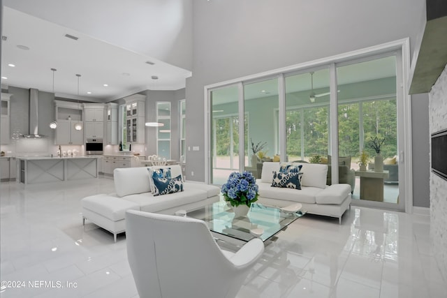 living area with a towering ceiling, visible vents, and recessed lighting