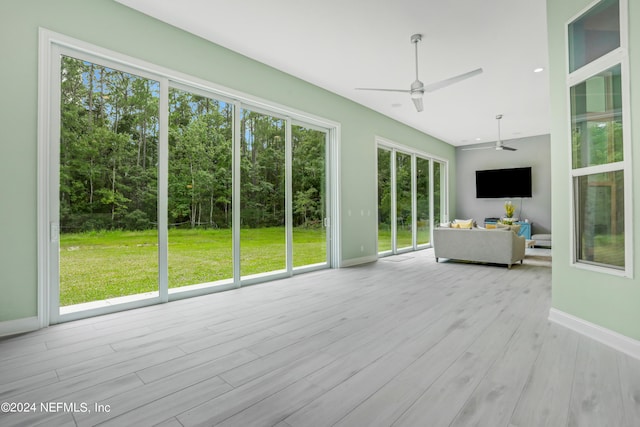 unfurnished sunroom featuring ceiling fan and plenty of natural light