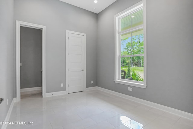 tiled spare room featuring a healthy amount of sunlight