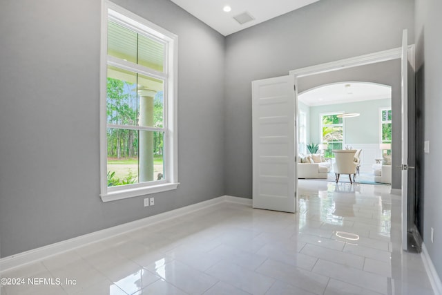 tiled spare room featuring plenty of natural light