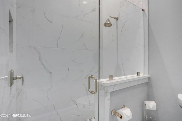 full bath featuring toilet and a marble finish shower