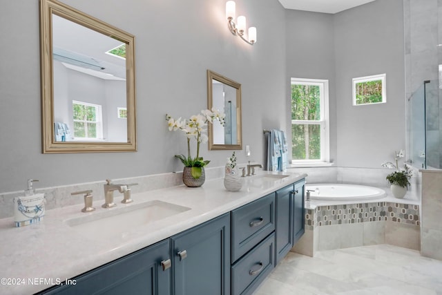 bathroom with tile patterned floors, tiled tub, and vanity