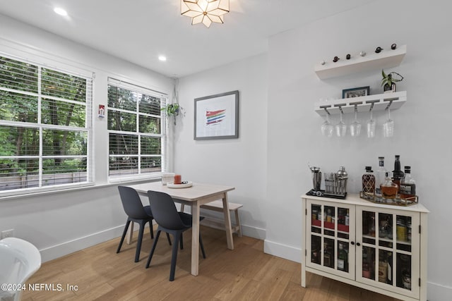 dining room with hardwood / wood-style flooring, a wealth of natural light, and indoor bar