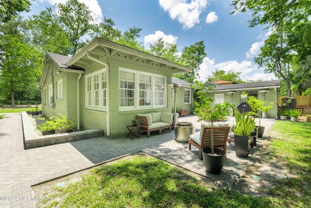 back of house featuring an outdoor living space and a patio