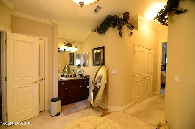 bathroom featuring vanity, crown molding, and vaulted ceiling