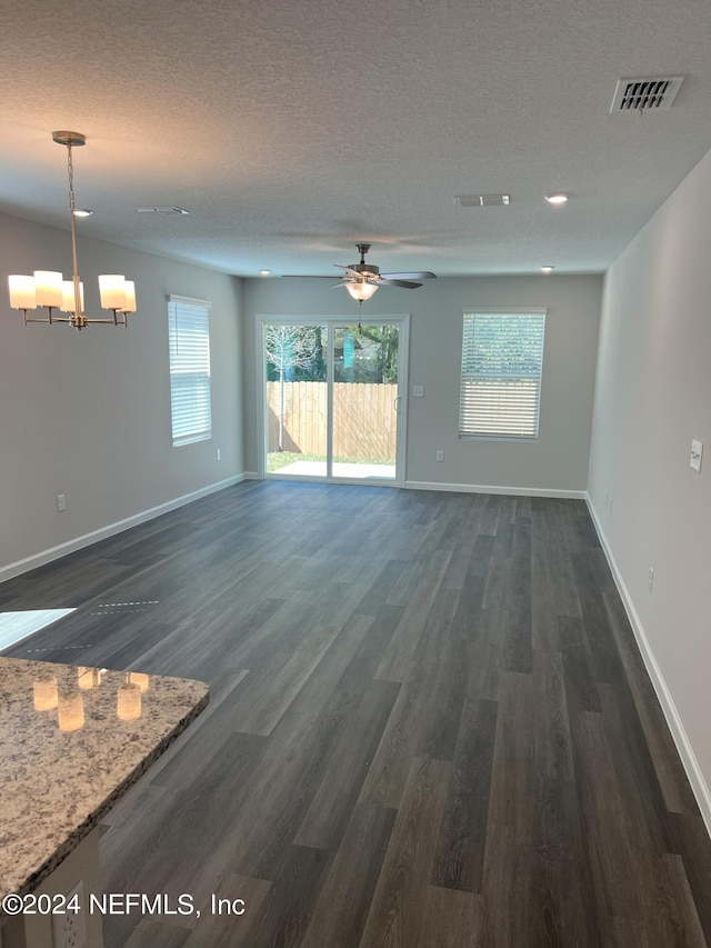 unfurnished living room featuring a textured ceiling, ceiling fan with notable chandelier, and dark hardwood / wood-style floors