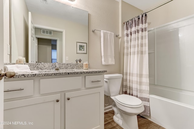 full bathroom featuring hardwood / wood-style floors, vanity, shower / tub combo, and toilet