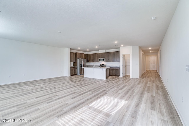 unfurnished living room with light hardwood / wood-style flooring and sink