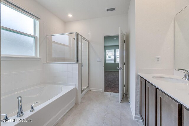 bathroom featuring vanity, visible vents, a bath, tile patterned floors, and a stall shower