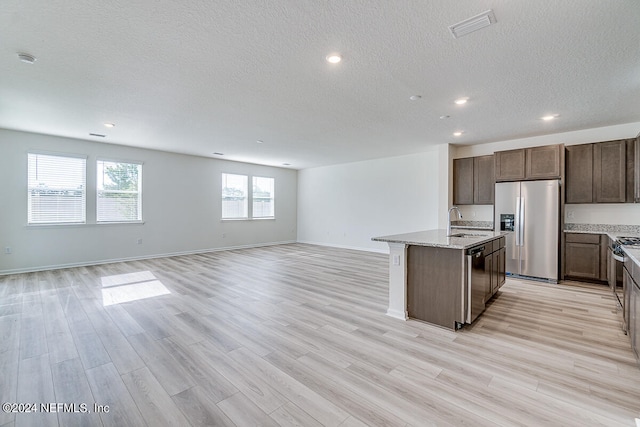 kitchen featuring sink, light hardwood / wood-style flooring, a center island with sink, and stainless steel appliances