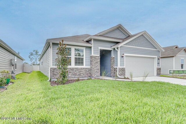 view of front of house with a garage, stone siding, concrete driveway, and a front yard