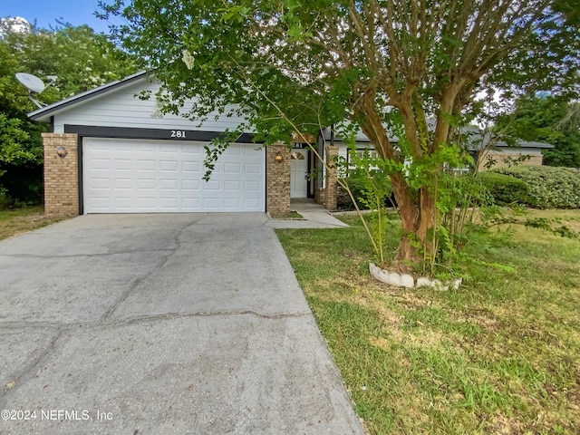 view of front of property with a front yard and a garage